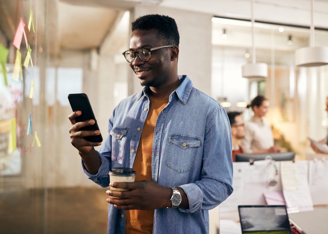 Man in an office looking at his phone